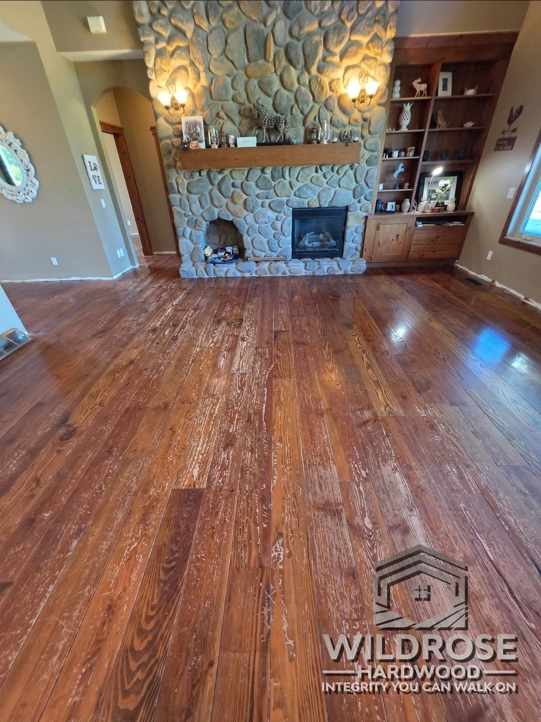 Fir hardwood floor with warm reddish stain before resanding, stone fireplace living room, Calgary Airdrie flooring refinishing