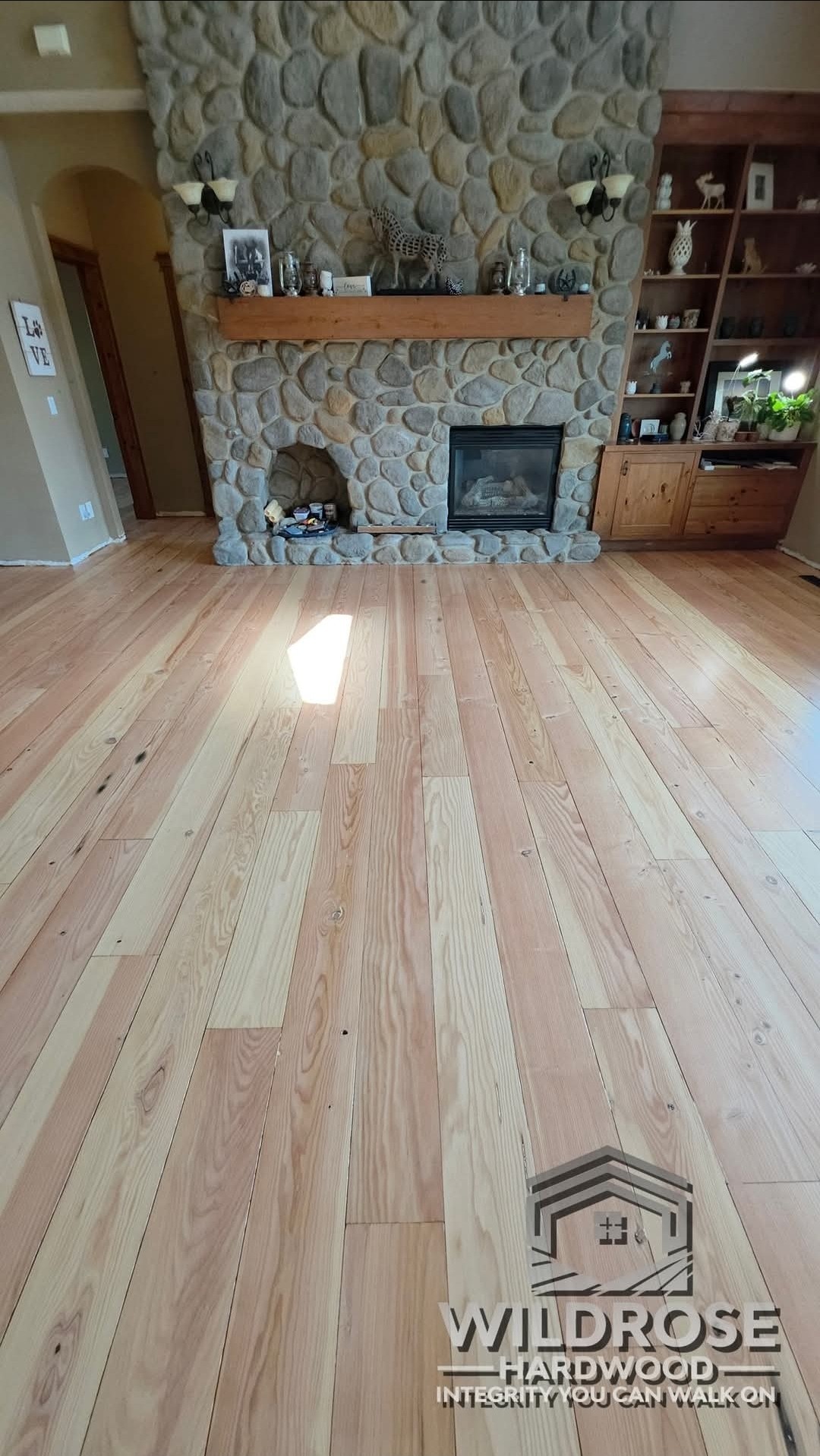 Fir hardwood floor resanded to natural finish, stone fireplace living room, by Wildrose Hardwood Calgary Airdrie